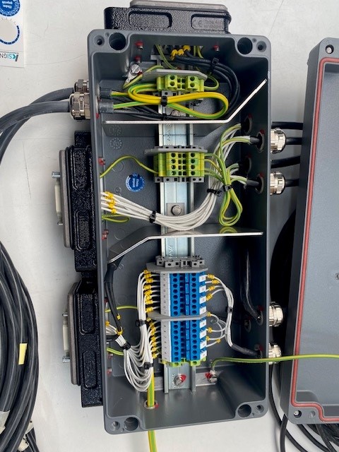 Offene Anschlussbox mit blau-grünen Klemmen.